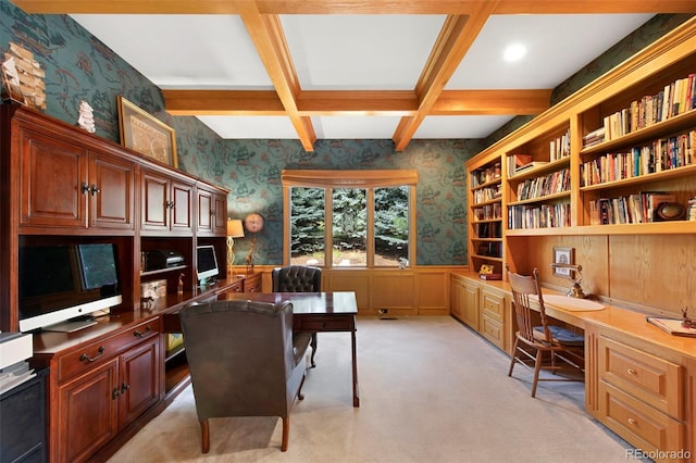 carpeted office featuring coffered ceiling, beam ceiling, and built in desk