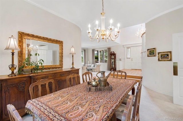 dining room with an inviting chandelier, crown molding, light carpet, and vaulted ceiling