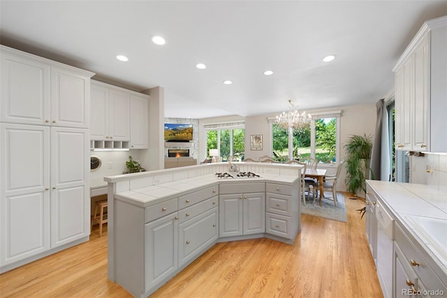 kitchen with tile countertops, a kitchen island, and white cabinets