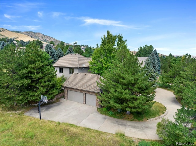 view of side of property with a mountain view and a garage