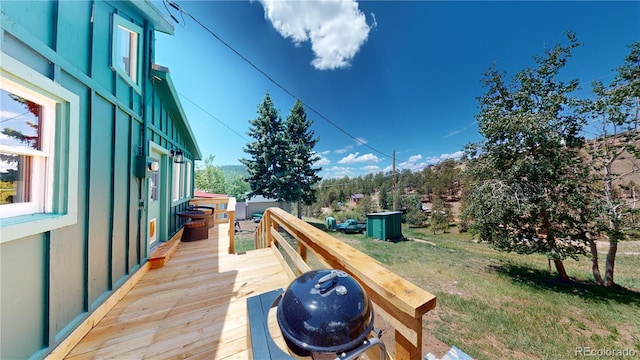 deck featuring a yard and grilling area