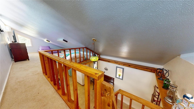 stairs featuring a textured ceiling, lofted ceiling, and carpet