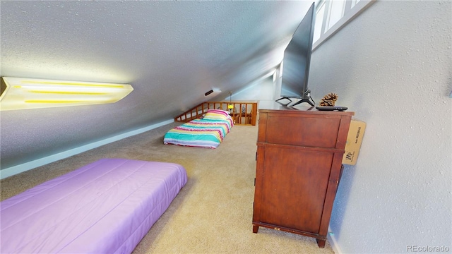 bedroom with light carpet, vaulted ceiling, and a textured ceiling