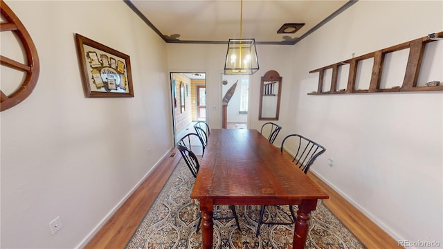 dining space featuring ornamental molding and hardwood / wood-style floors