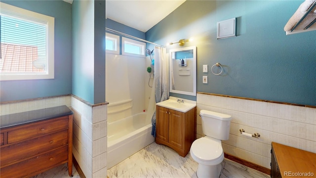 full bathroom with tile walls, toilet, vanity, and shower / bathtub combination with curtain