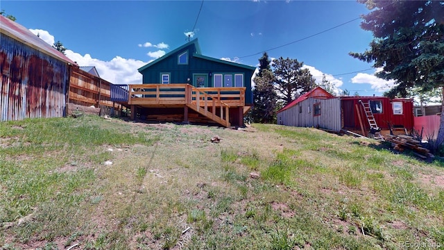 rear view of property featuring a wooden deck and an outbuilding