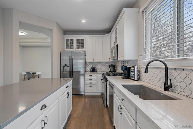 kitchen with sink, white cabinetry, tasteful backsplash, dark hardwood / wood-style floors, and stainless steel appliances