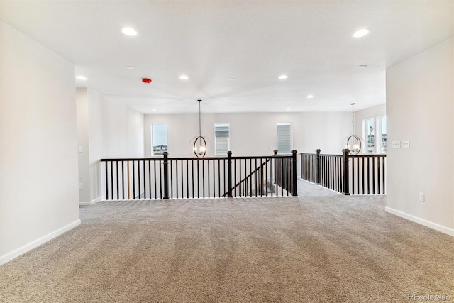 unfurnished room with carpet and a notable chandelier