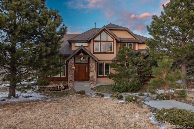 tudor house featuring stucco siding and stone siding