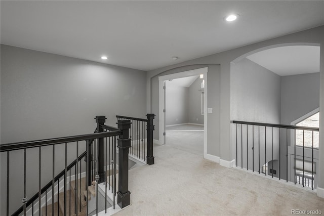 corridor with baseboards, an upstairs landing, carpet flooring, recessed lighting, and arched walkways