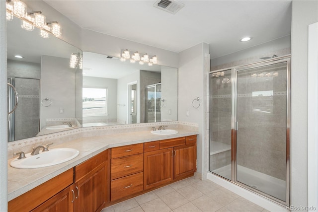full bathroom with tile patterned floors, visible vents, a shower stall, and a sink