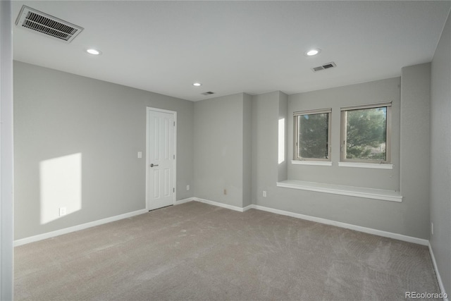 carpeted spare room with recessed lighting, baseboards, and visible vents