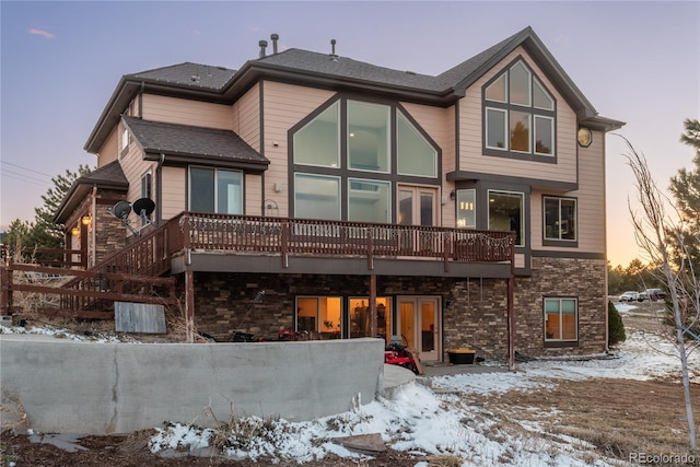snow covered house with stone siding