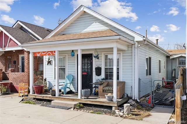 4445 Pearl St, Denver, CO 80216 - shotgun-style home with a porch, a gate, and a shingled roof