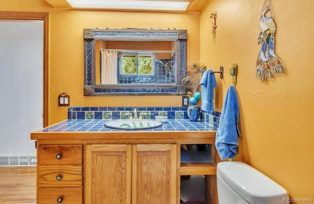 bathroom with visible vents, vanity, and toilet