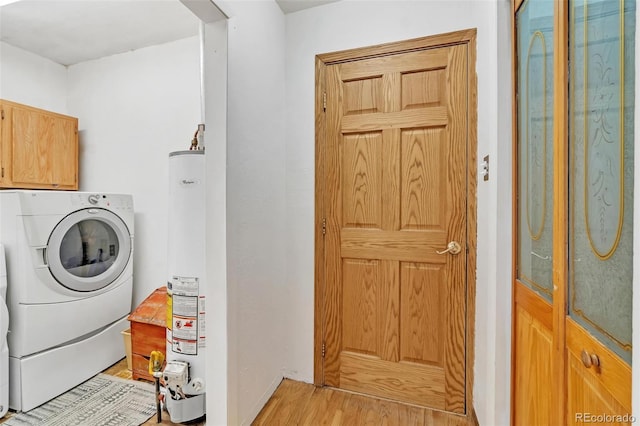 washroom featuring washer / clothes dryer, gas water heater, cabinets, and light hardwood / wood-style floors