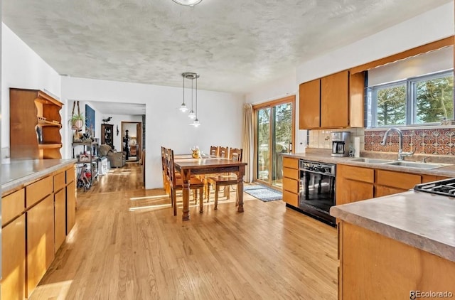 kitchen featuring beverage cooler, light wood-style flooring, decorative light fixtures, a sink, and backsplash