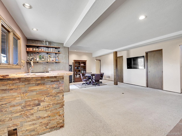 bar with light carpet and a textured ceiling