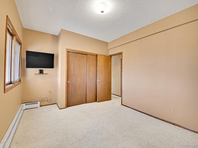 unfurnished bedroom featuring a closet, a baseboard heating unit, and a textured ceiling