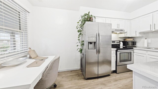677 Vrain St Unit 15, Denver, CO 80204 - kitchen with stainless steel appliances, under cabinet range hood, backsplash, and light wood-style flooring