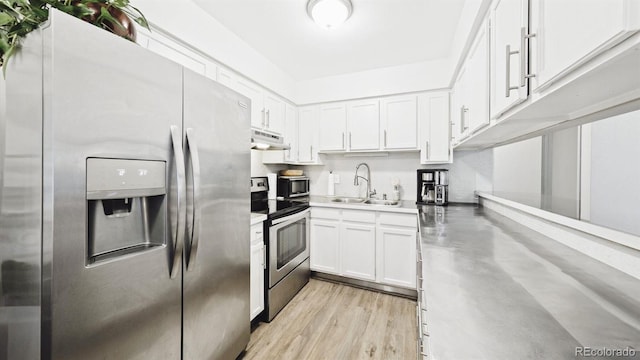 677 Vrain St Unit 15, Denver, CO 80204 - kitchen with appliances with stainless steel finishes, a sink, under cabinet range hood, and white cabinetry