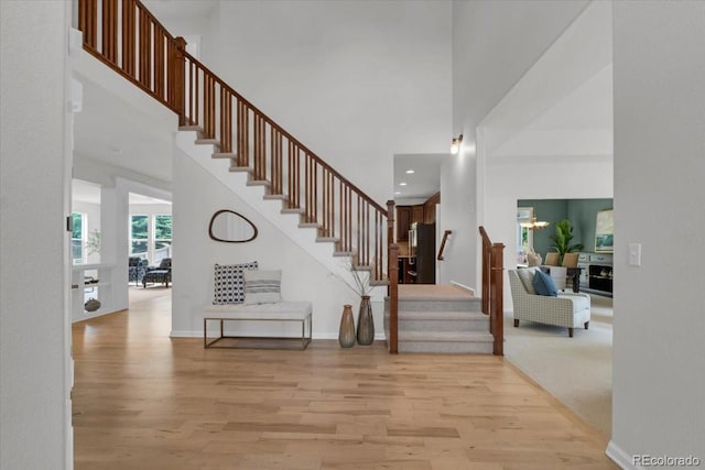 10683 Amesbury Way, Highlands Ranch, CO 80126 - staircase featuring wood finished floors, a towering ceiling, recessed lighting, and a fireplace