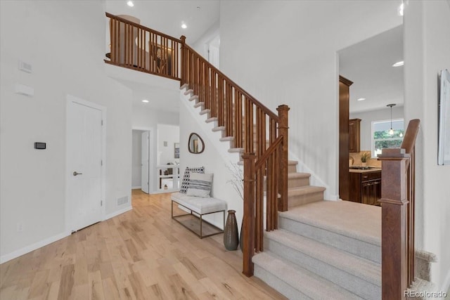 10683 Amesbury Way, Highlands Ranch, CO 80126 - stairs featuring wood finished floors, recessed lighting, and a high ceiling