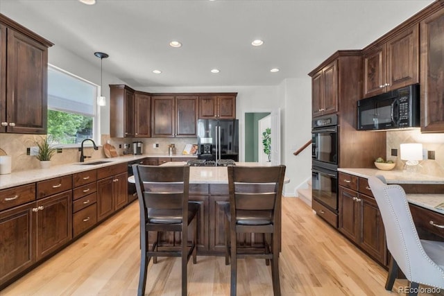 10683 Amesbury Way, Highlands Ranch, CO 80126 - kitchen with black appliances, light wood-style floors, backsplash, dark brown cabinets, and recessed lighting