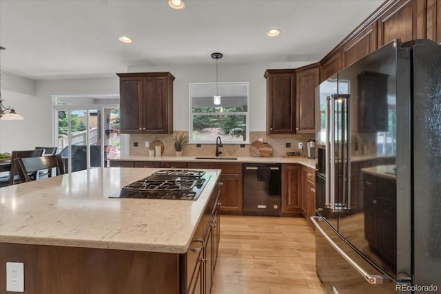 10683 Amesbury Way, Highlands Ranch, CO 80126 - kitchen featuring black appliances, plenty of natural light, light wood finished floors, decorative light fixtures, and recessed lighting