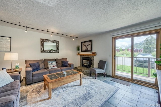 23004 US Highway 6 Unit 103, Dillon, CO 80435 - tiled living area featuring rail lighting, a tiled fireplace, and a textured ceiling