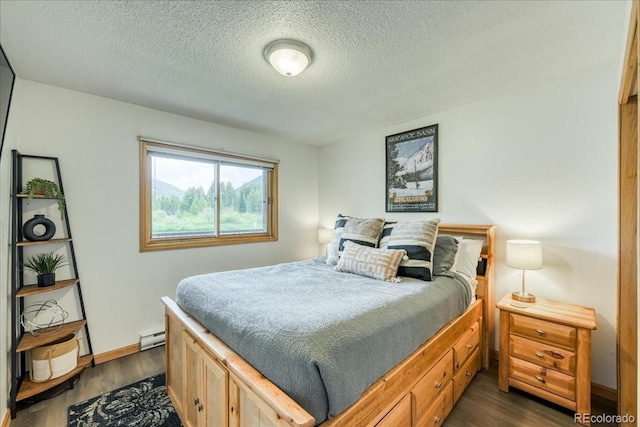 23004 US Highway 6 Unit 103, Dillon, CO 80435 - bedroom featuring dark wood-style flooring, a textured ceiling, and a baseboard radiator