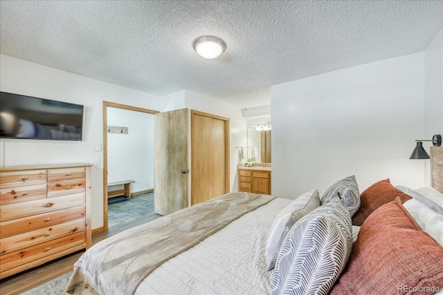 23004 US Highway 6 Unit 103, Dillon, CO 80435 - bedroom featuring ensuite bathroom and a textured ceiling