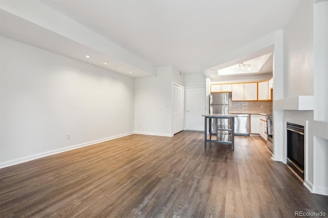 2824 W Centennial Dr Unit L, Littleton, CO 80123 - unfurnished living room featuring dark wood-style floors, baseboards, recessed lighting, and a glass covered fireplace