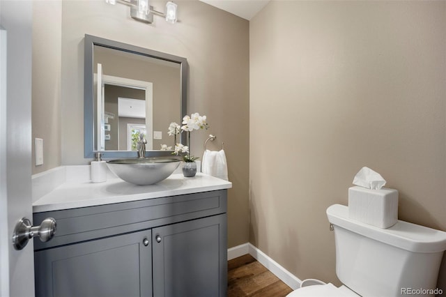 5 Sanford Rd, Colorado Springs, CO 80906 - half bathroom featuring vanity, wood finished floors, toilet, and baseboards