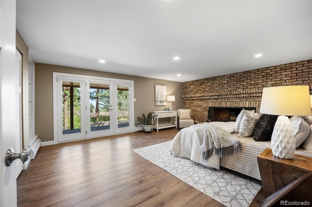 5 Sanford Rd, Colorado Springs, CO 80906 - bedroom with a baseboard heating unit, access to exterior, wood finished floors, recessed lighting, and a fireplace