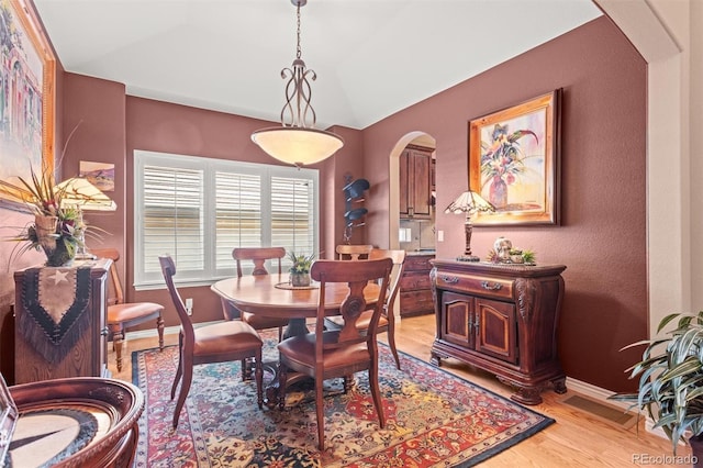 8070 W Progress Cir, Littleton, CO 80123 - dining space with arched walkways, light wood finished floors, and lofted ceiling