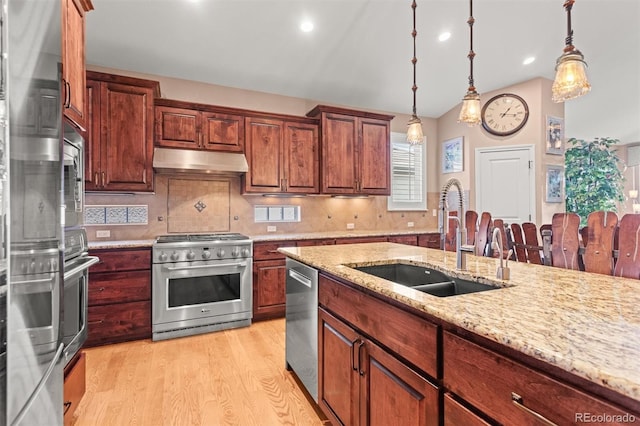 8070 W Progress Cir, Littleton, CO 80123 - kitchen with stainless steel appliances, under cabinet range hood, light wood-style flooring, decorative backsplash, and pendant lighting