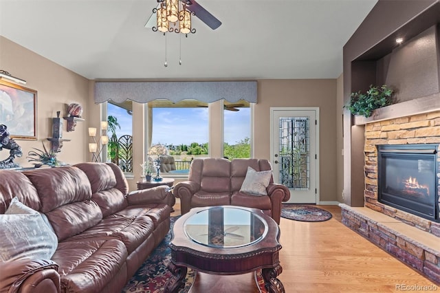 8070 W Progress Cir, Littleton, CO 80123 - living area featuring a ceiling fan, plenty of natural light, wood finished floors, and a stone fireplace