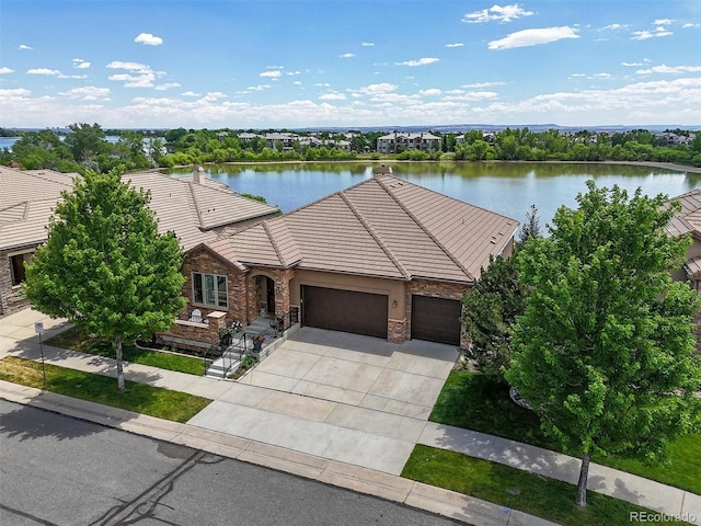 8070 W Progress Cir, Littleton, CO 80123 - view of front of property featuring an attached garage, a tile roof, a water view, and stone siding