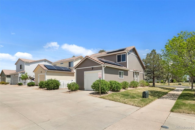 4713 Perth St, Denver, CO 80249 - traditional-style home featuring roof mounted solar panels, a garage, stucco siding, driveway, and a front lawn