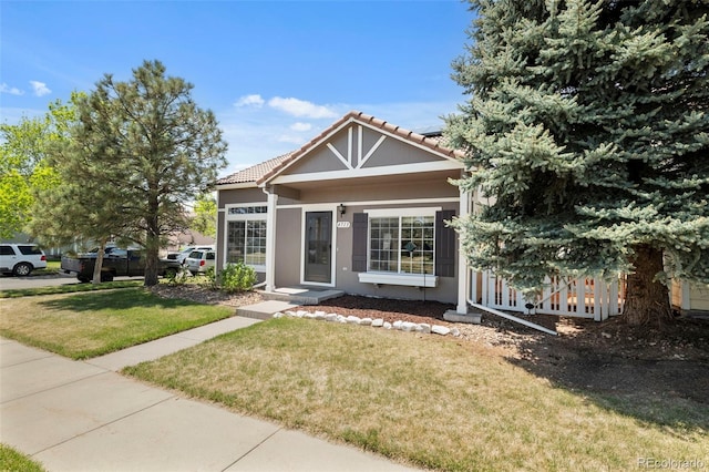 4713 Perth St, Denver, CO 80249 - view of front facade featuring a front lawn, a tile roof, and stucco siding