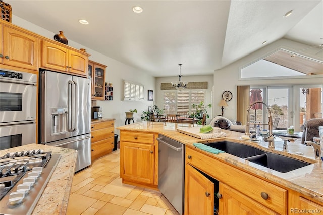 kitchen featuring appliances with stainless steel finishes, sink, plenty of natural light, and decorative light fixtures