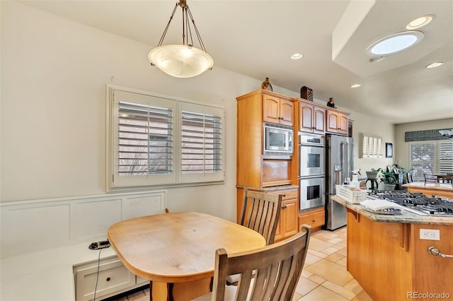 kitchen with pendant lighting, appliances with stainless steel finishes, and a breakfast bar