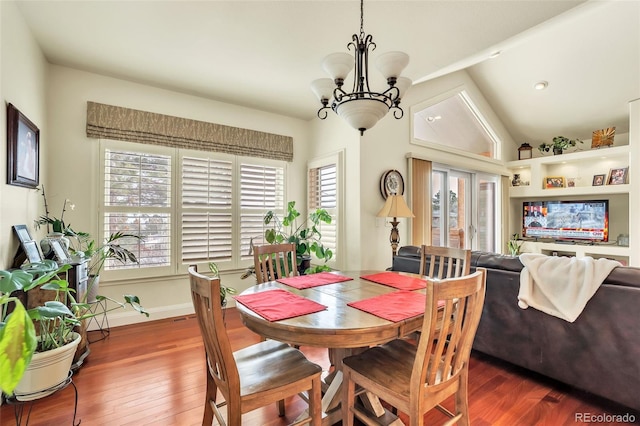 dining space featuring lofted ceiling, an inviting chandelier, and dark hardwood / wood-style flooring