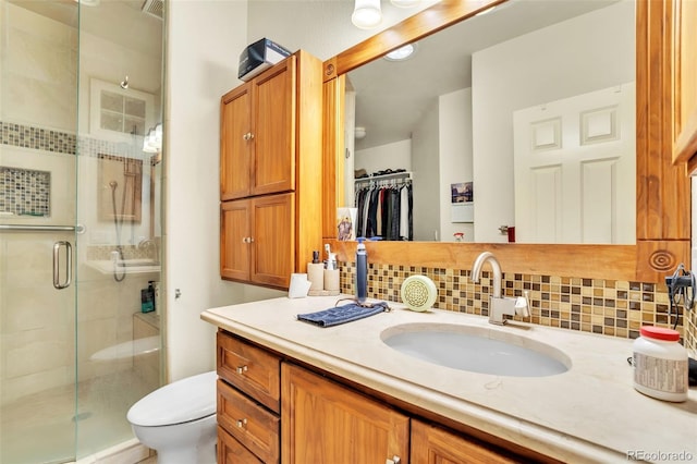 bathroom featuring vanity, decorative backsplash, and walk in shower