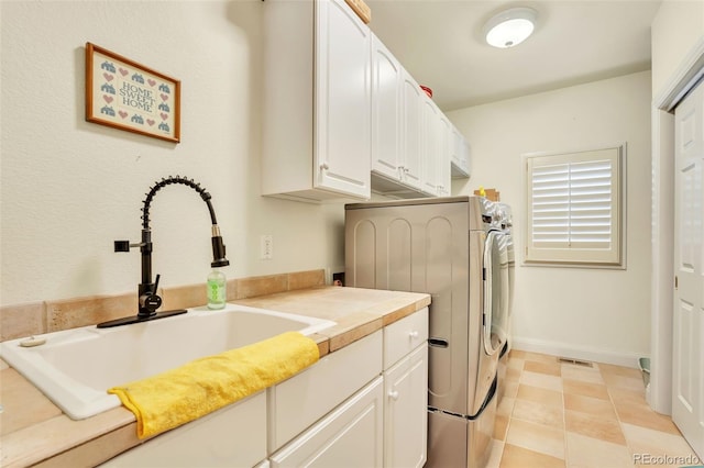 laundry room with separate washer and dryer, sink, and cabinets