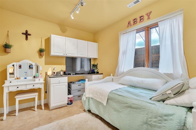 bedroom with rail lighting and light tile patterned floors