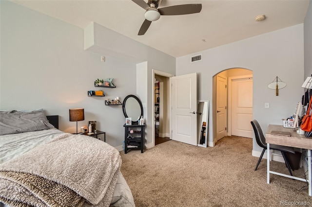 bedroom featuring arched walkways, light colored carpet, visible vents, ceiling fan, and baseboards