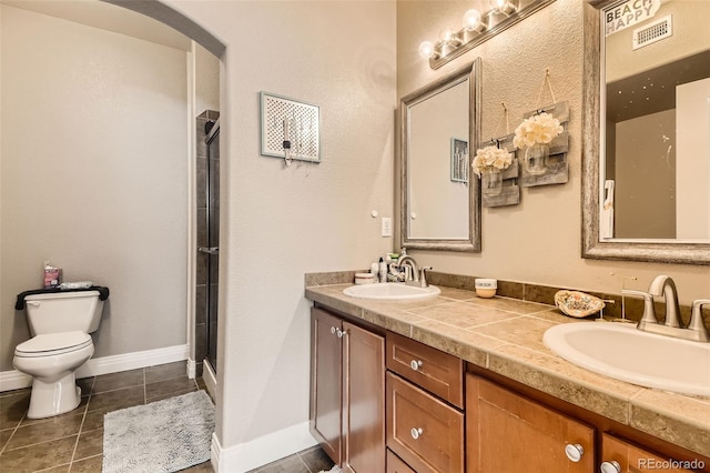 full bathroom featuring double vanity, a sink, toilet, and tile patterned floors