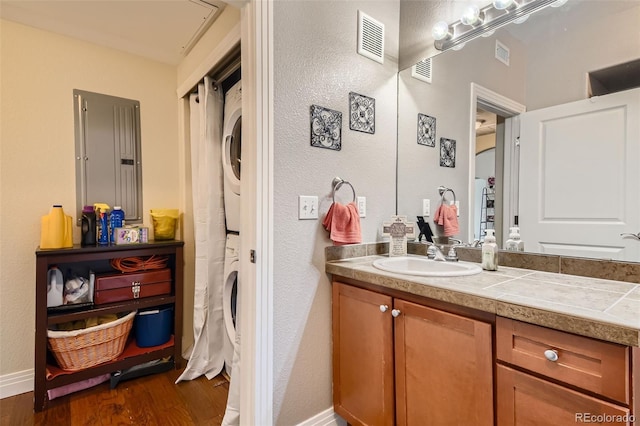 full bathroom with vanity, visible vents, wood finished floors, and stacked washer and clothes dryer